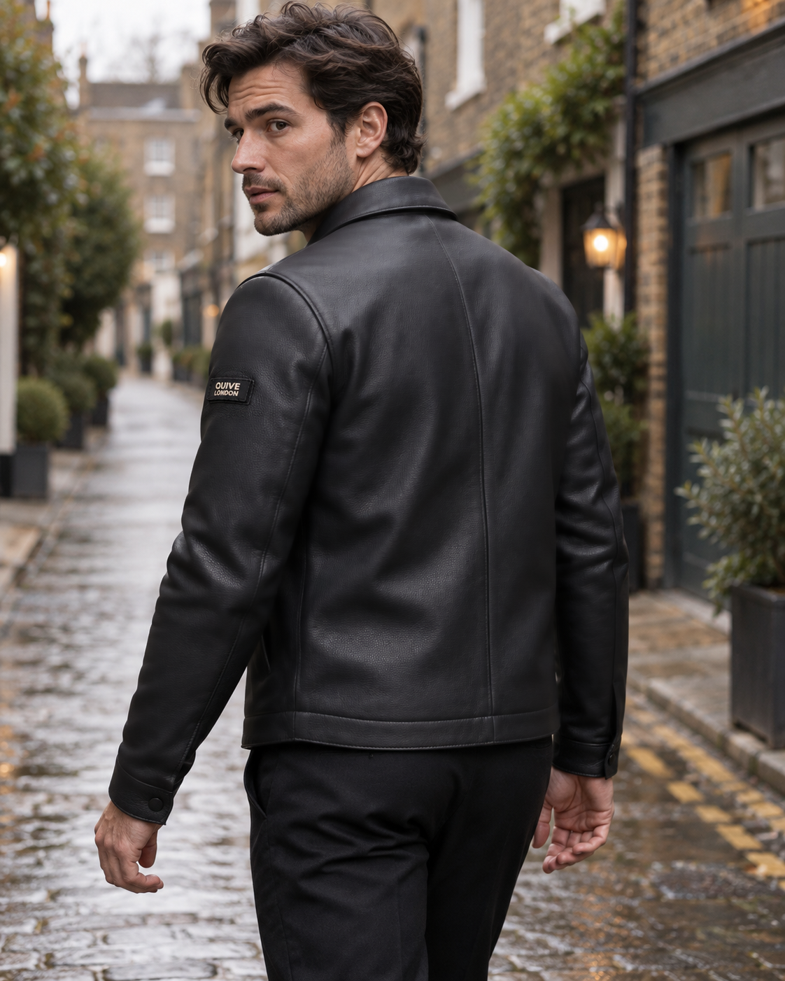 Male model wearing the SLOANE black leather jacket from the rear in a softly blurred London mews