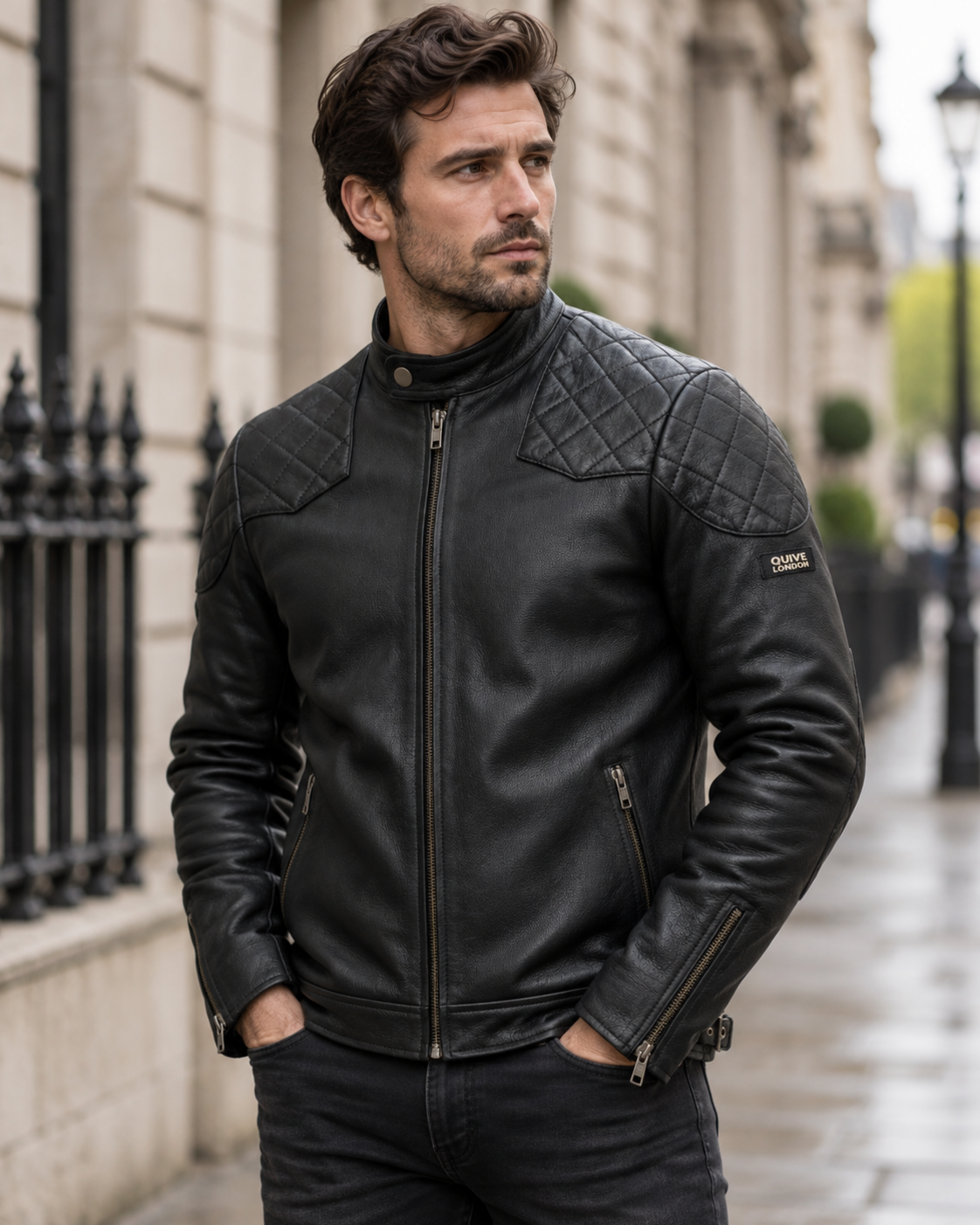 Male model wearing the black QUIVE London BROMPTON leather biker jacket on a softly blurred London street