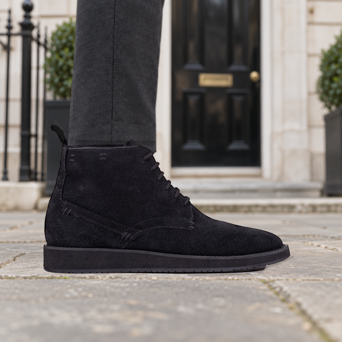 Model wearing black QUIVE London CHESTER suede chukka boots on a London street