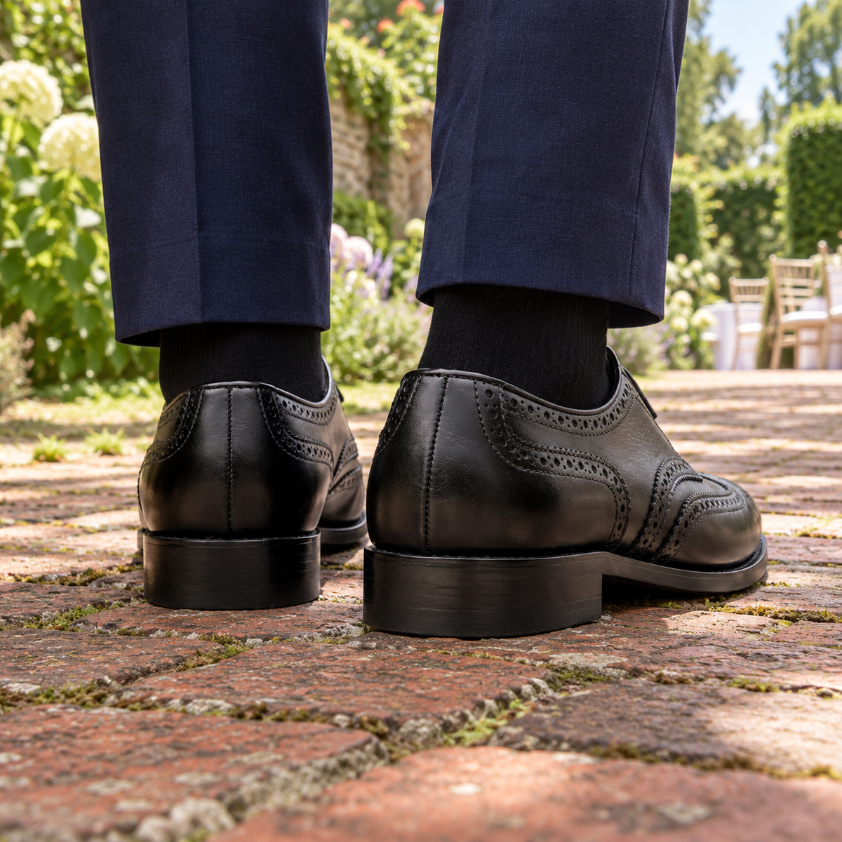 Rear view of WESTMINSTER black calf leather wingtip Derby shoes in a wedding garden